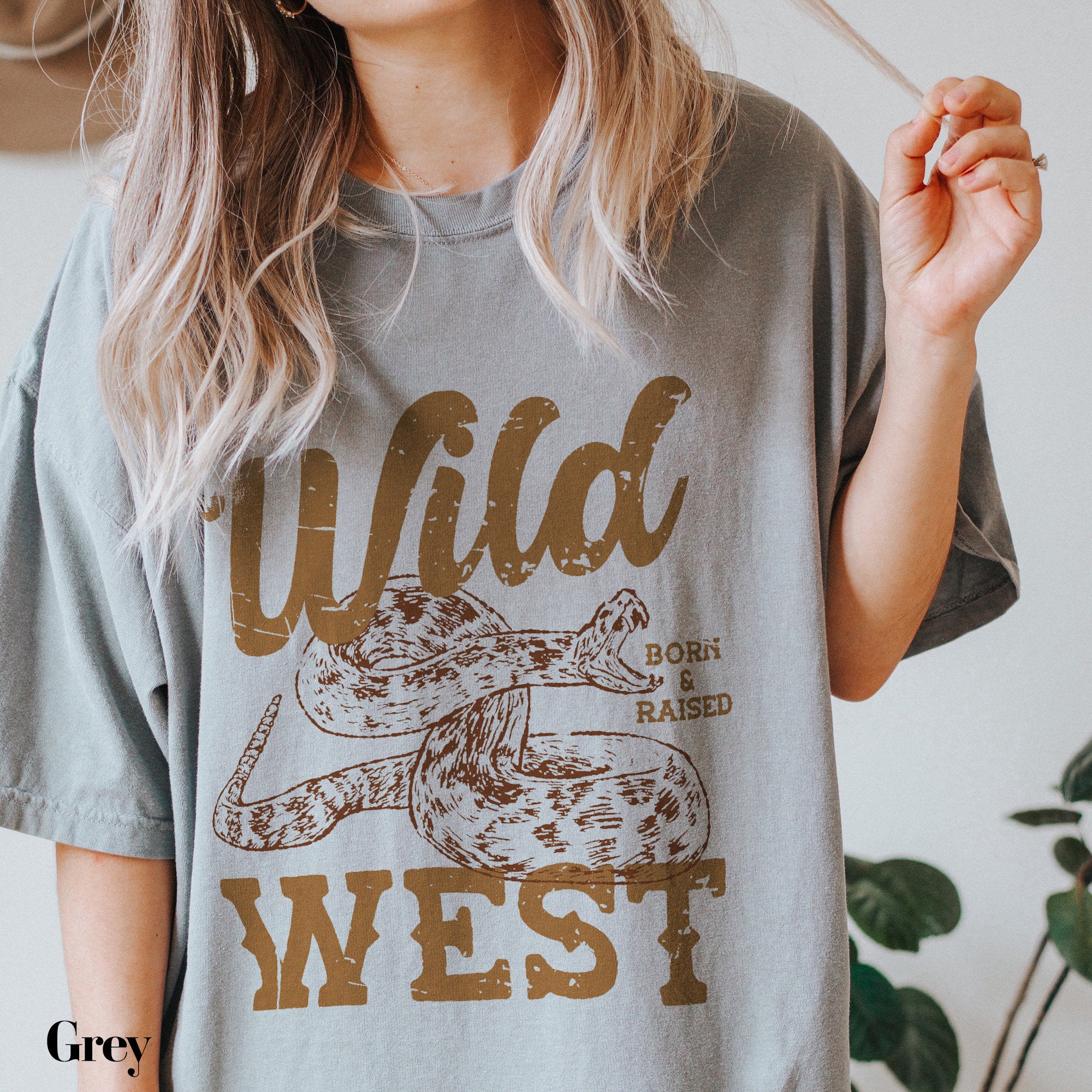 a woman holding a cigarette and wearing a wild west t - shirt