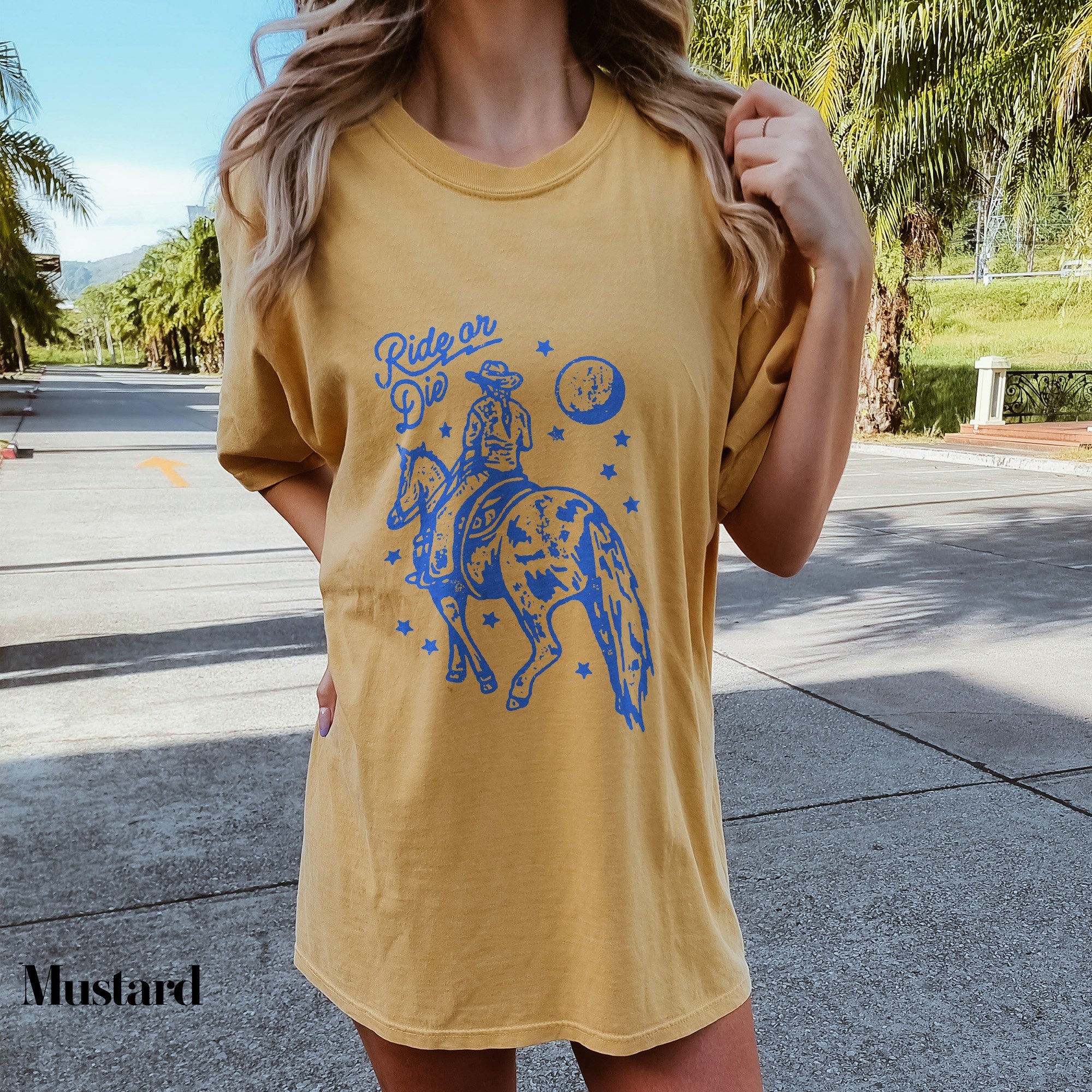 a woman wearing a yellow shirt with a blue horse on it