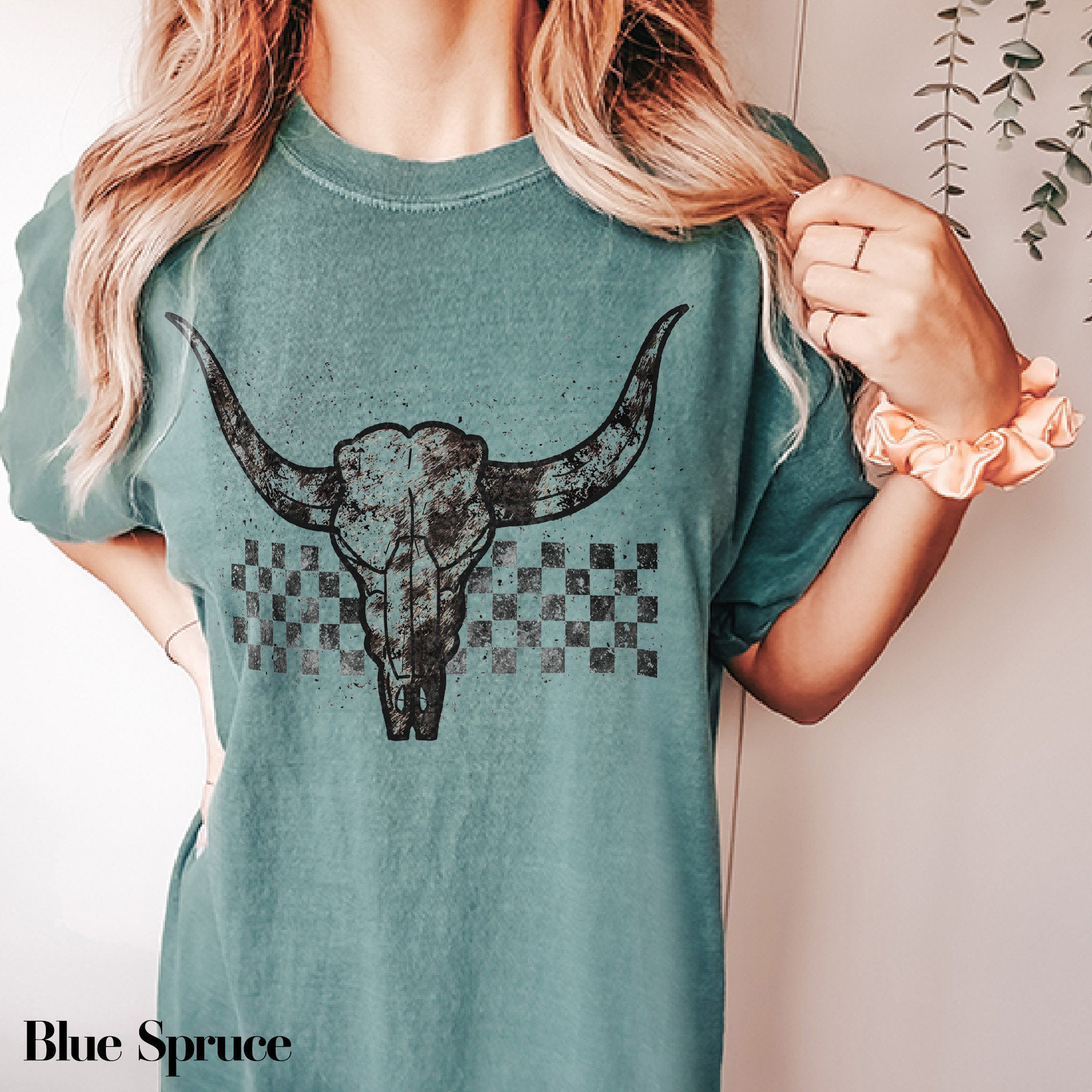 a woman wearing a green shirt with a bull&#39;s head on it