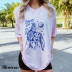 a woman wearing a white shirt with a blue graphic on it
