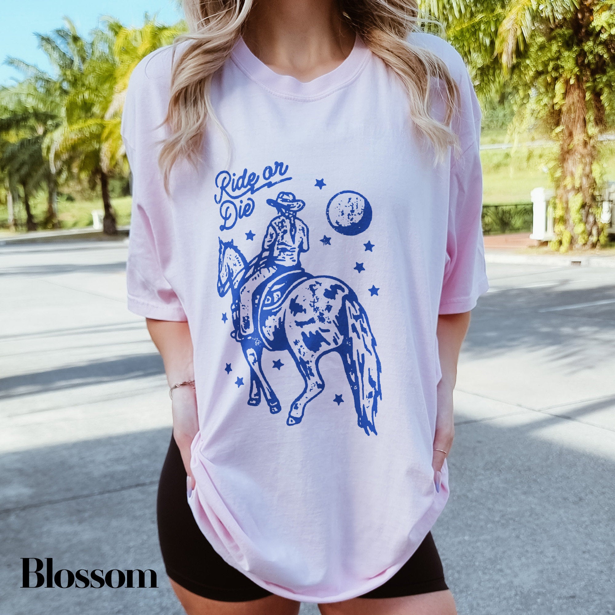a woman wearing a white shirt with a blue graphic on it