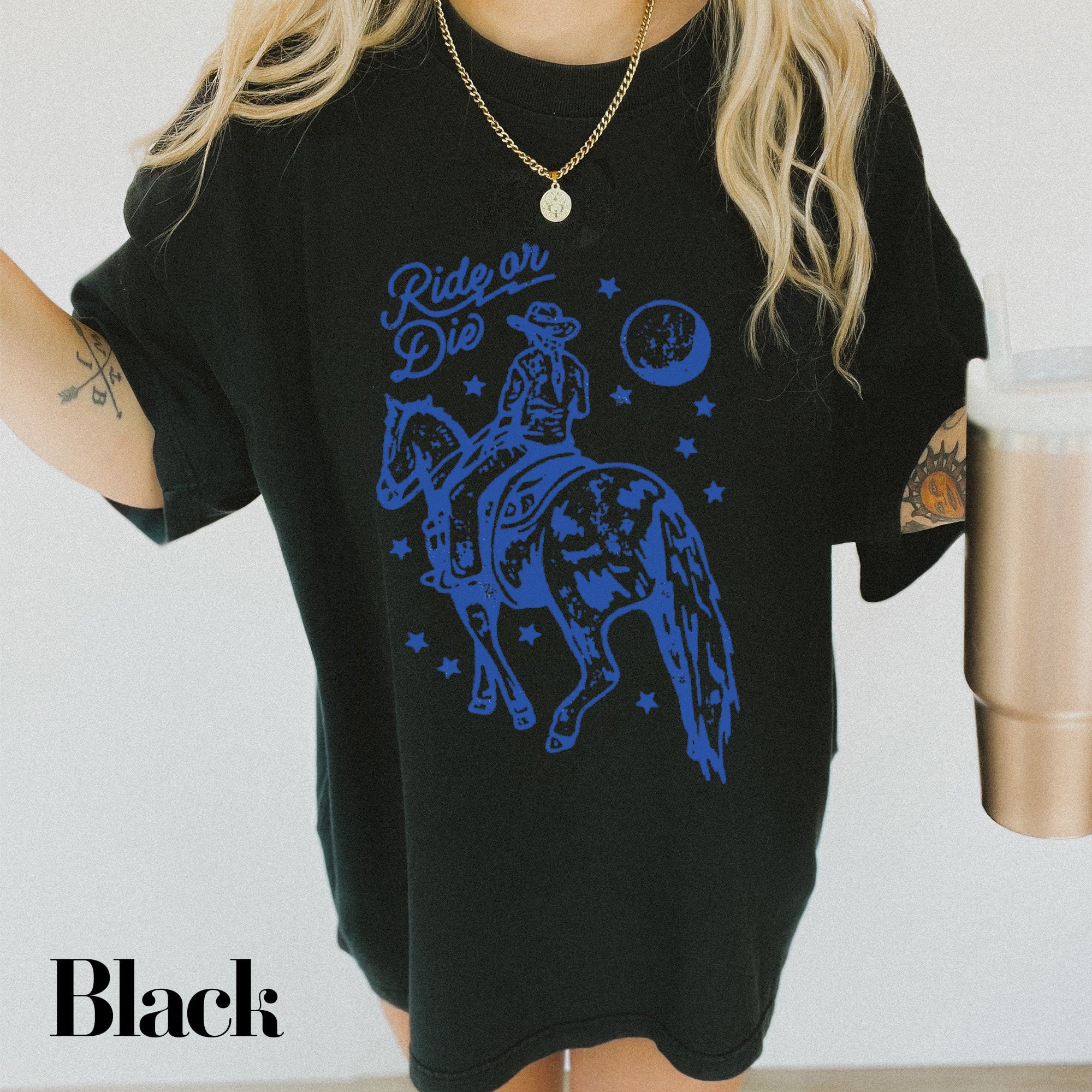 a woman wearing a black shirt with a blue horse on it