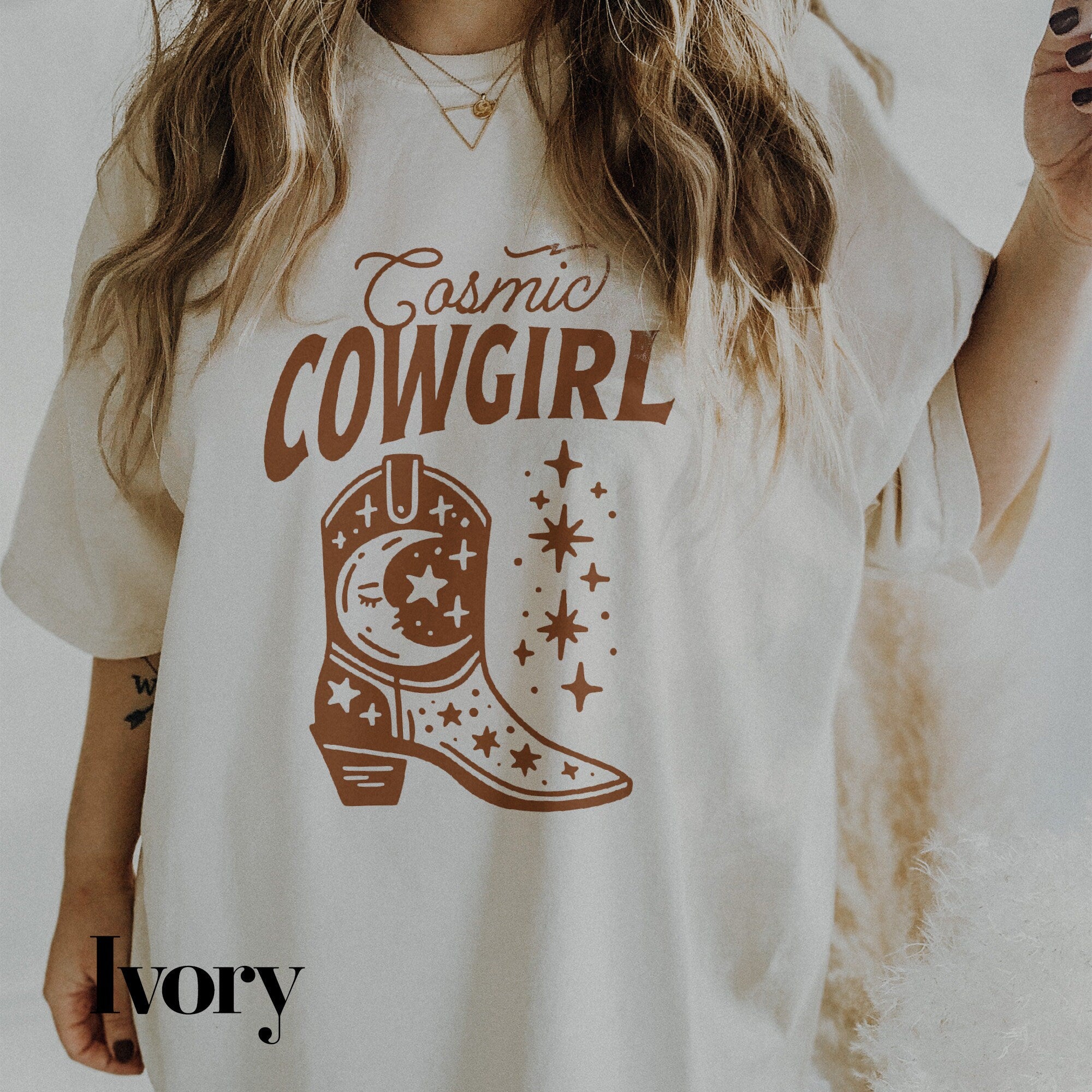a woman wearing a cowboy t - shirt holding a cigarette