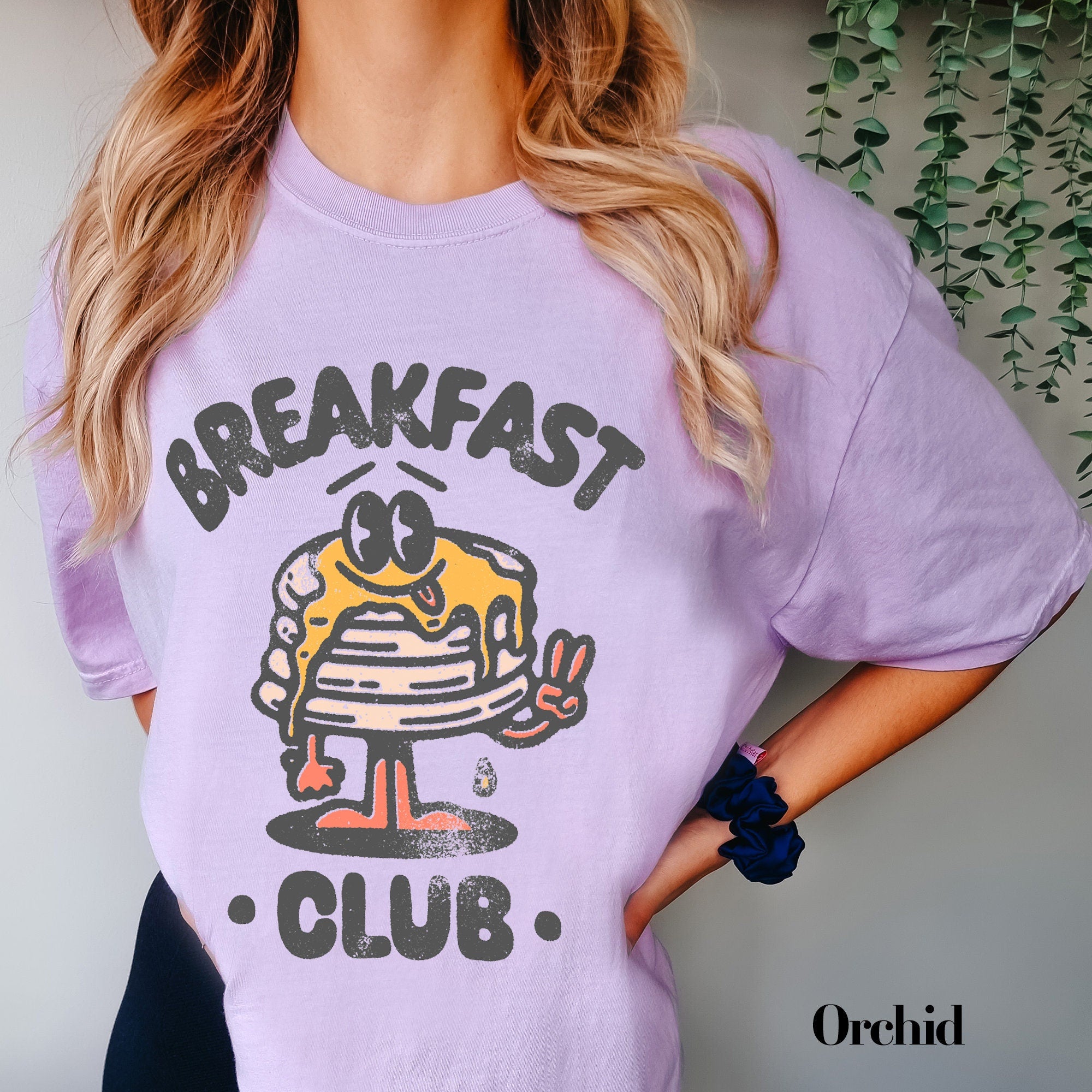 a woman wearing a purple breakfast club shirt