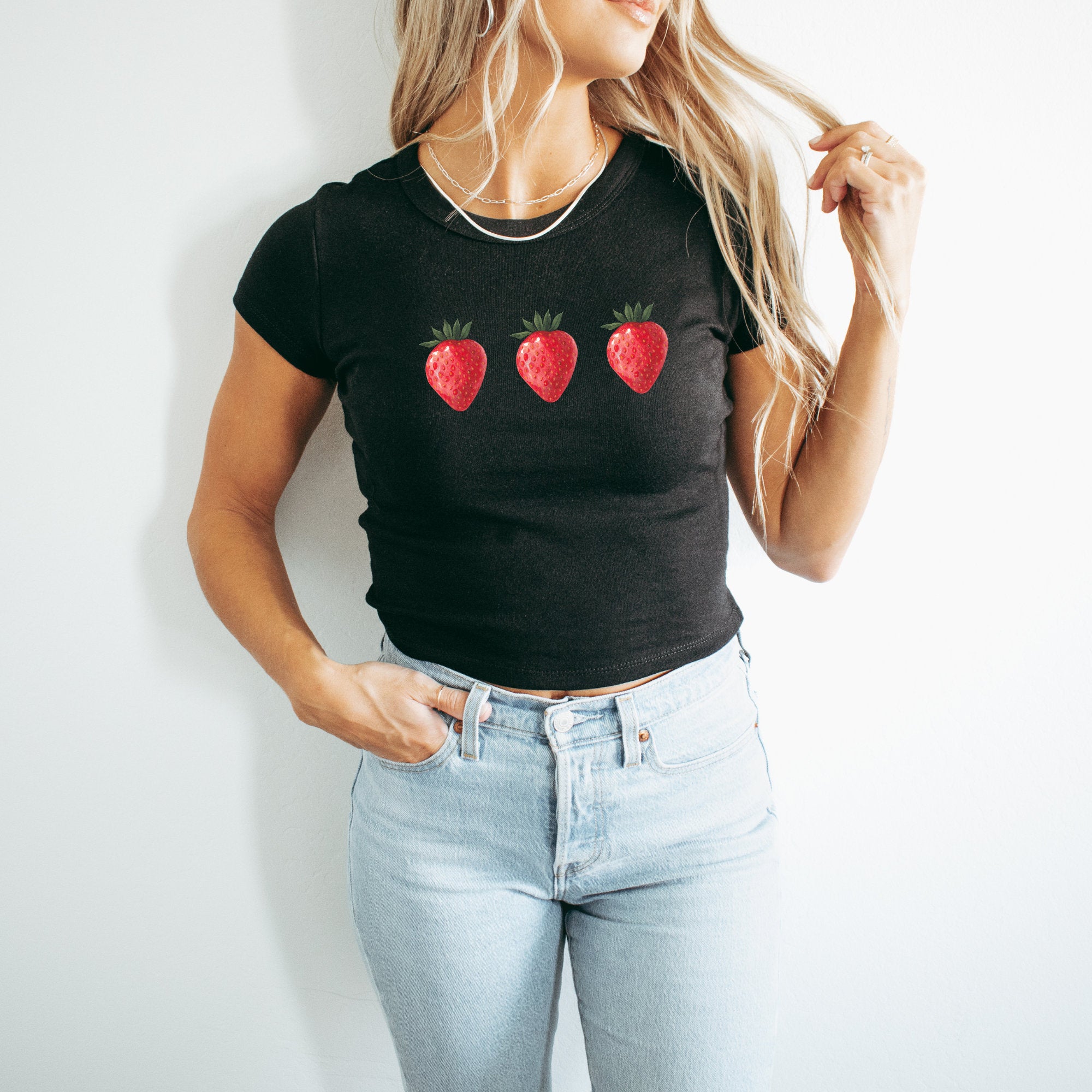 a woman wearing a black shirt with strawberries on it