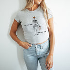 a woman wearing a t - shirt with a skeleton holding a tennis racquet