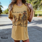 a woman wearing a yellow shirt with a cowboy on it