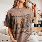 a woman sitting on a couch wearing a brown shirt