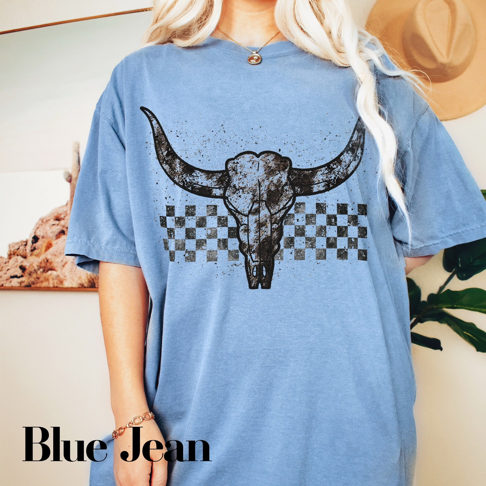a woman wearing a blue shirt with a cow skull on it