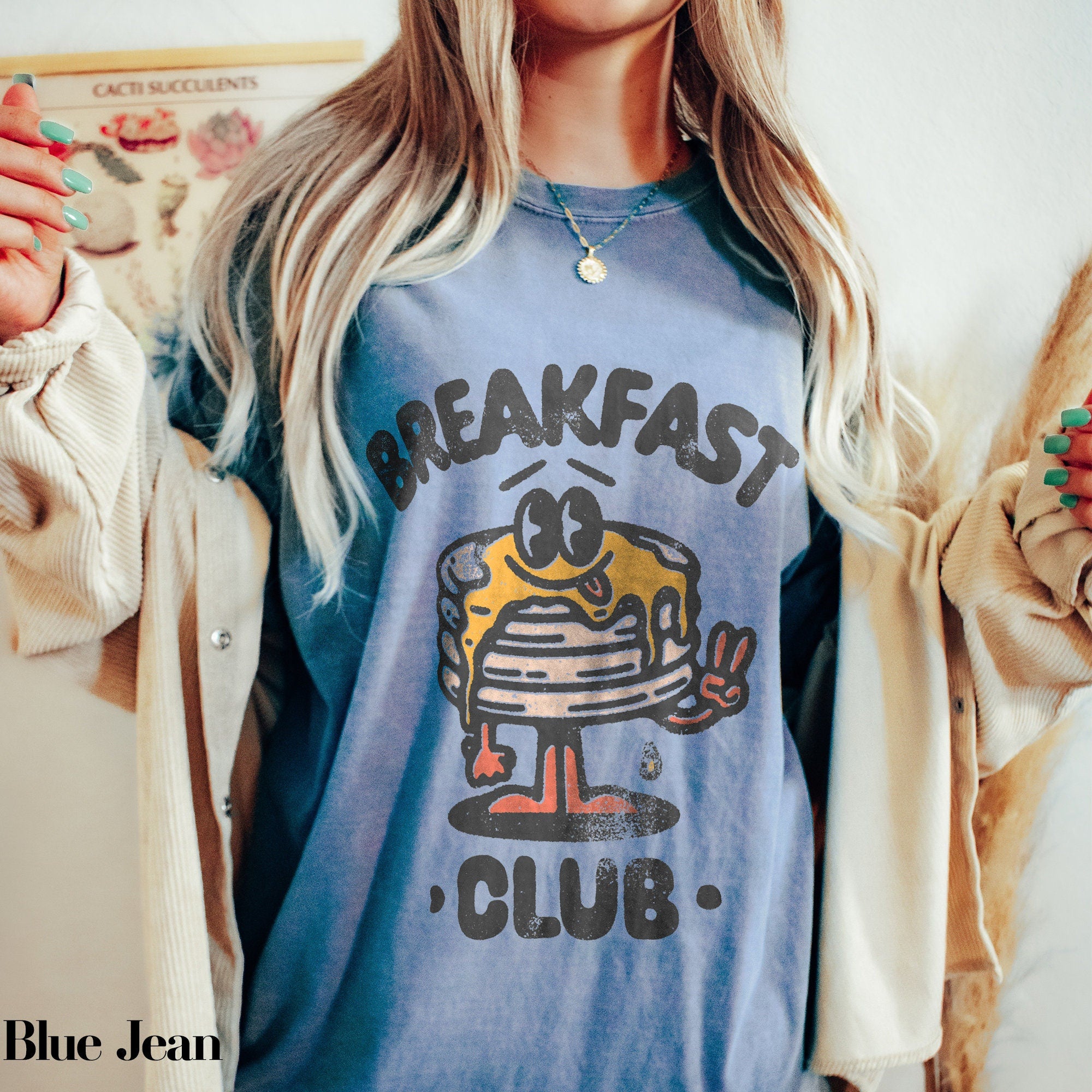 a blonde woman wearing a breakfast club shirt