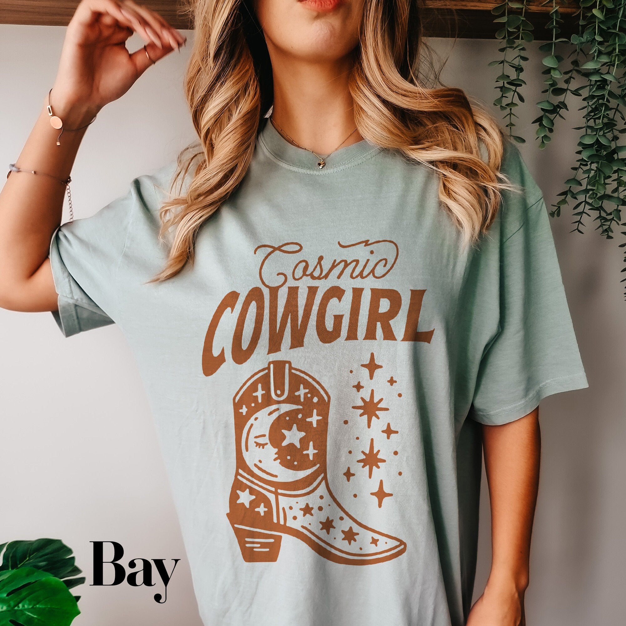 a woman wearing a t - shirt that says cosmic cowgirl