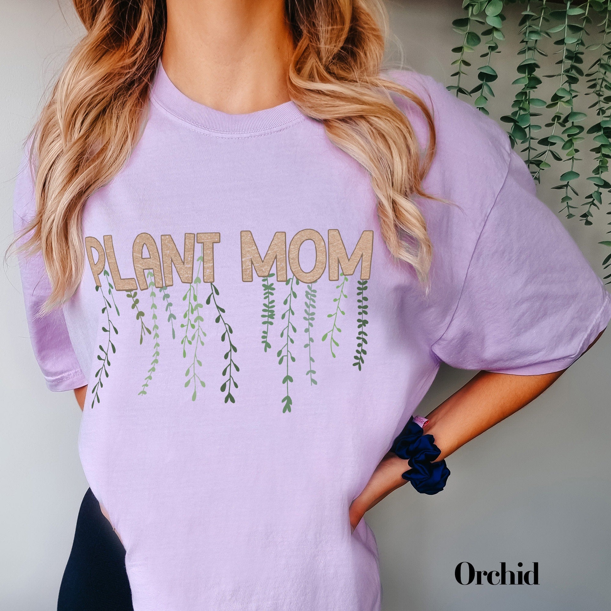 a woman wearing a purple shirt that says plant mom