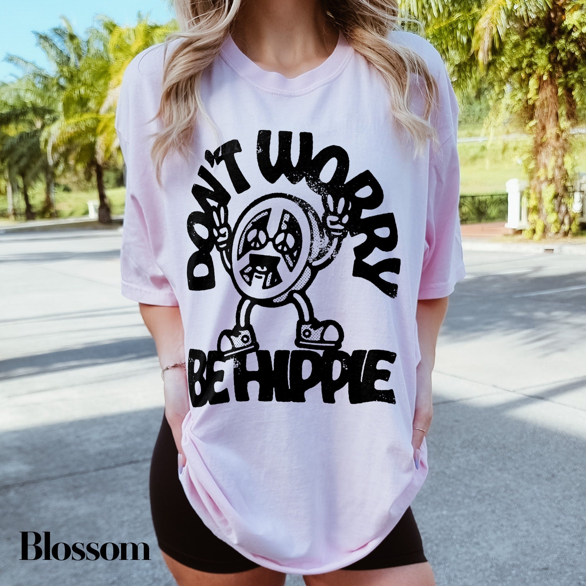 a woman wearing a t - shirt that says don&#39;t worry be hippie