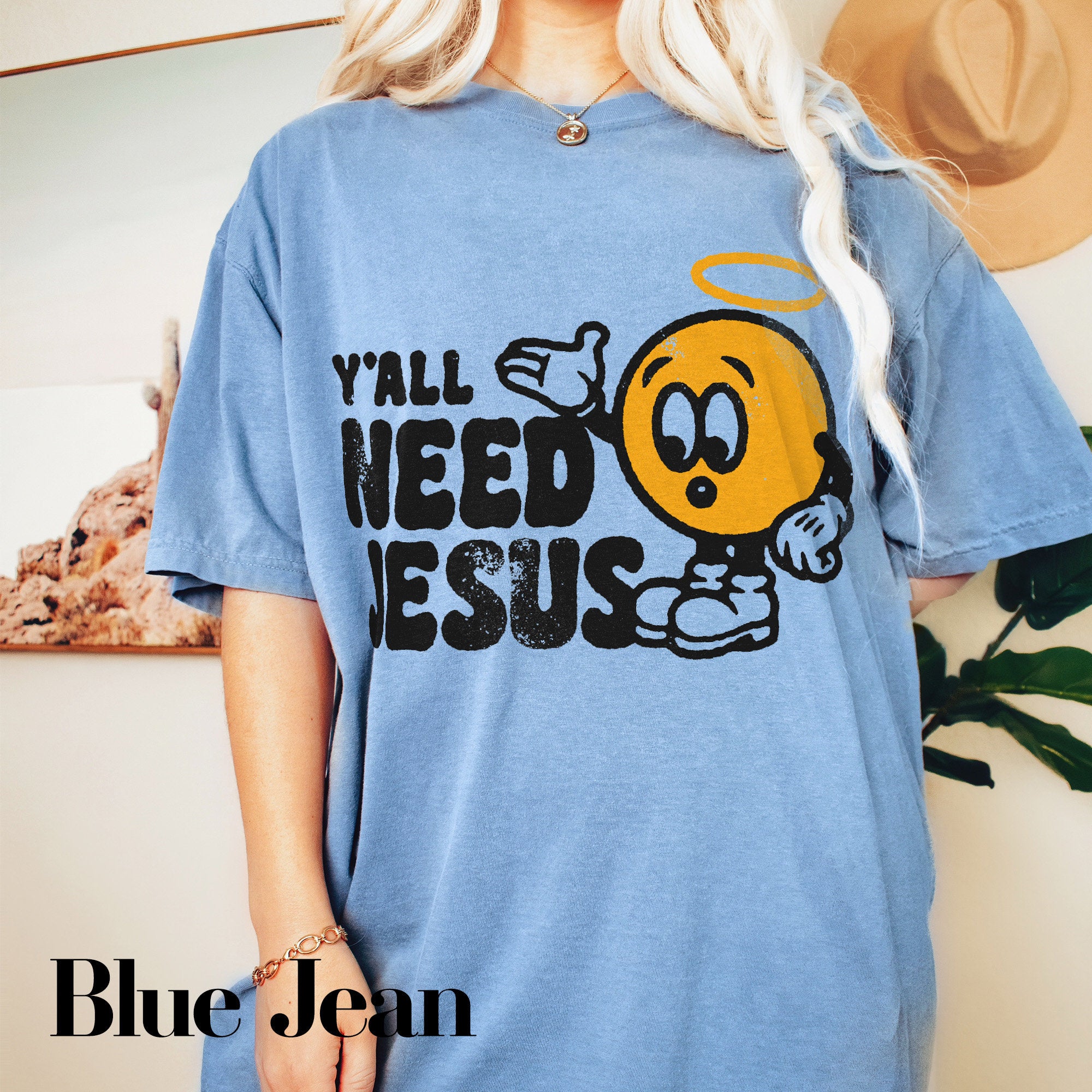 a blonde woman wearing a blue shirt with a smiley face on it