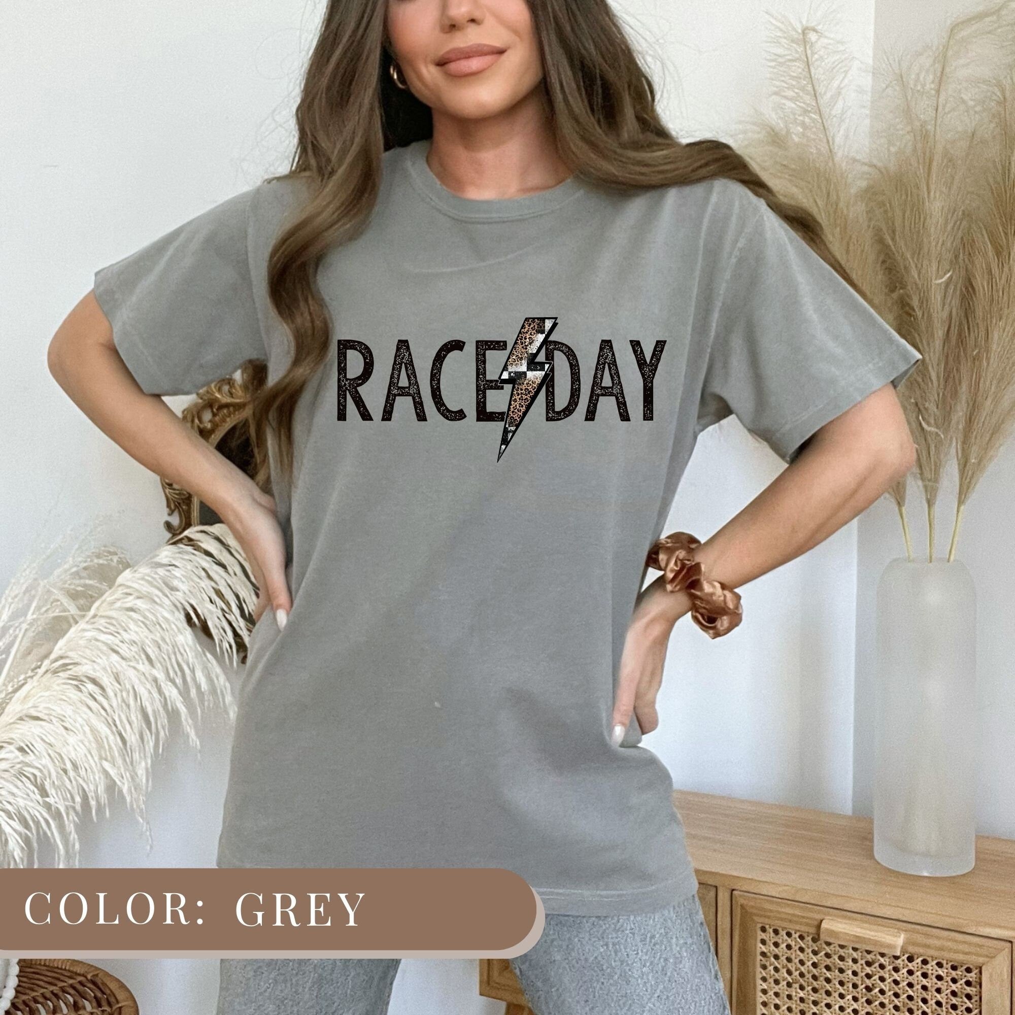 a woman wearing a gray race day shirt
