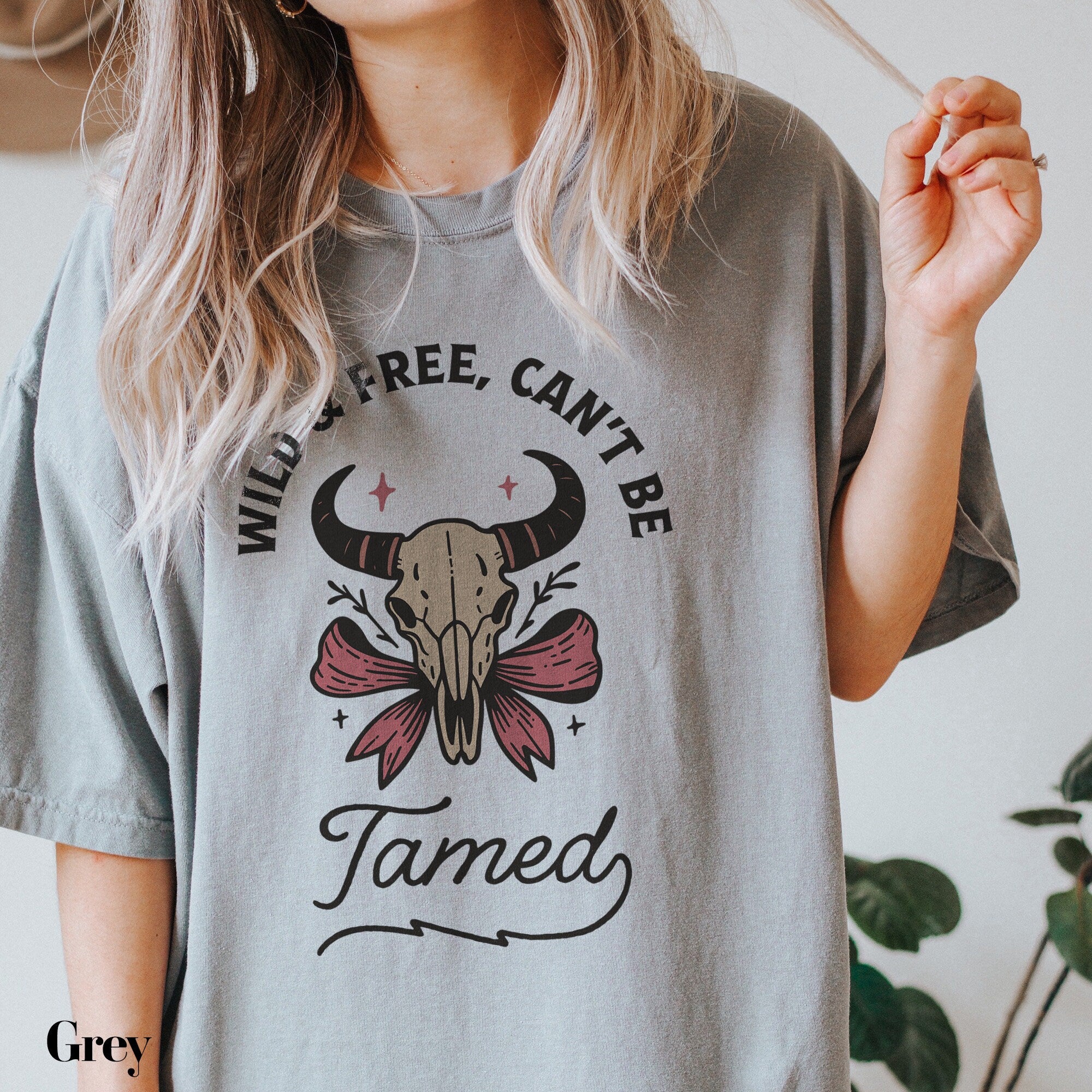 a woman holding a cigarette and wearing a t - shirt that says wild, free