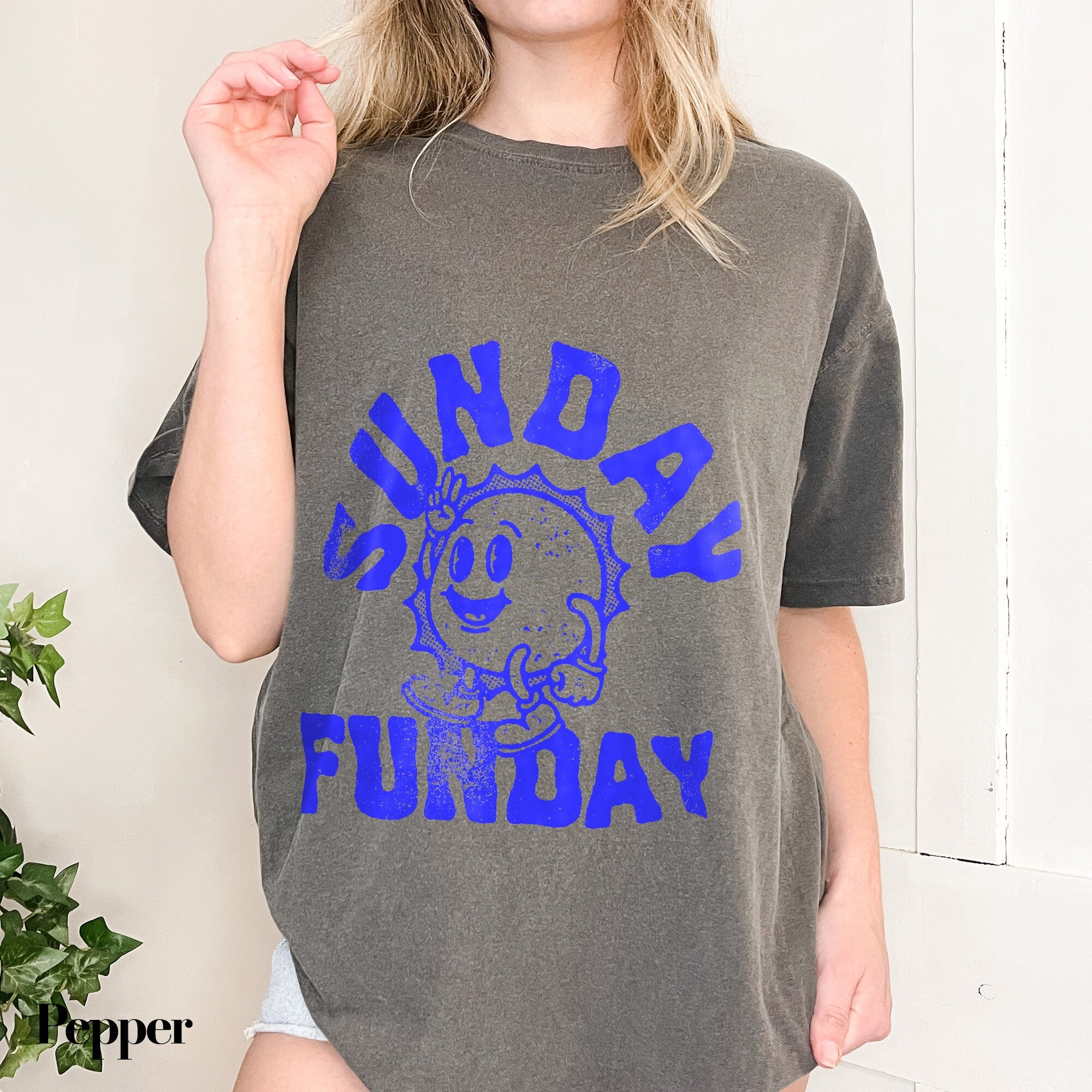 a woman wearing a gray shirt with blue writing on it