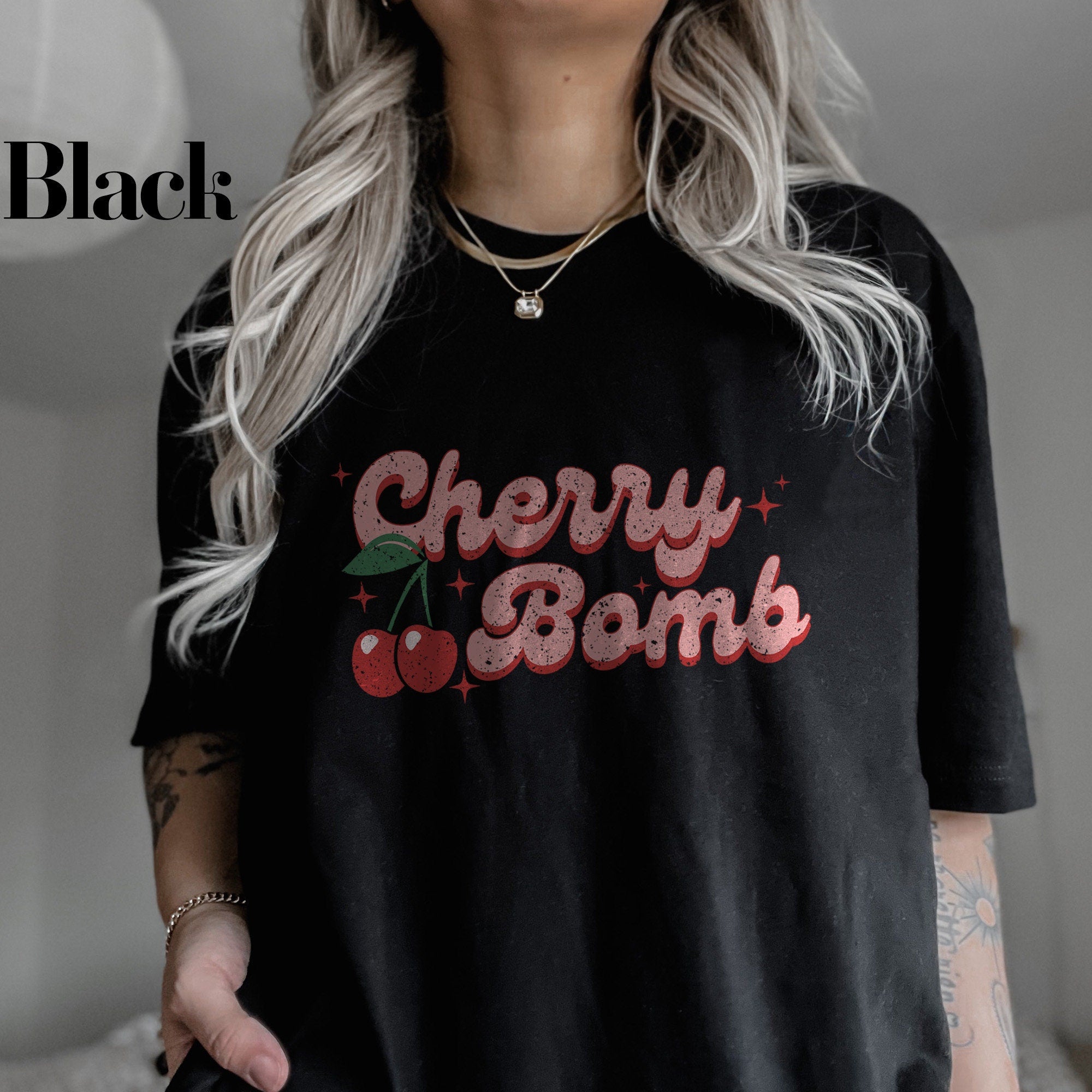 a woman wearing a black cherry bomb t - shirt