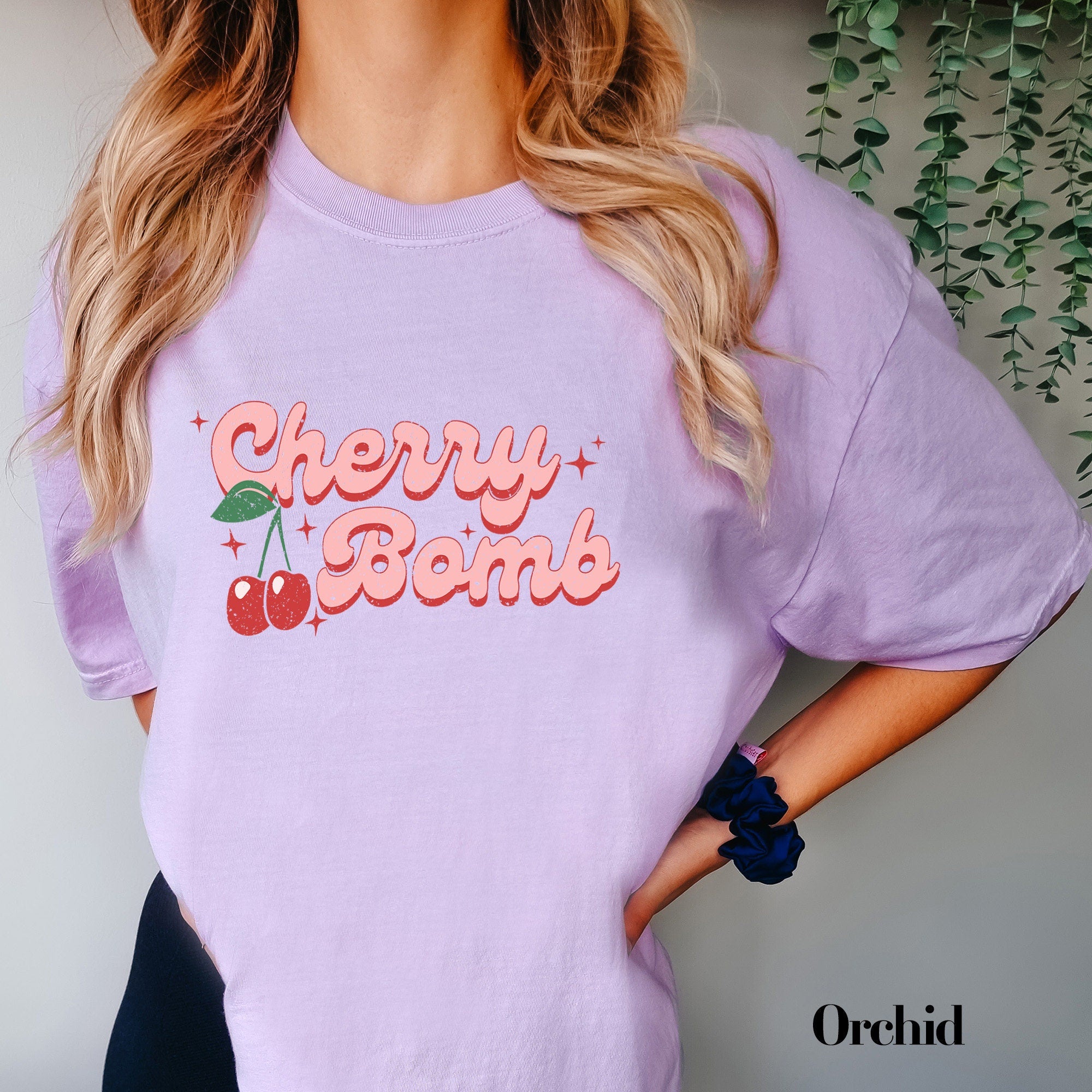 a woman wearing a cherry bomb t - shirt