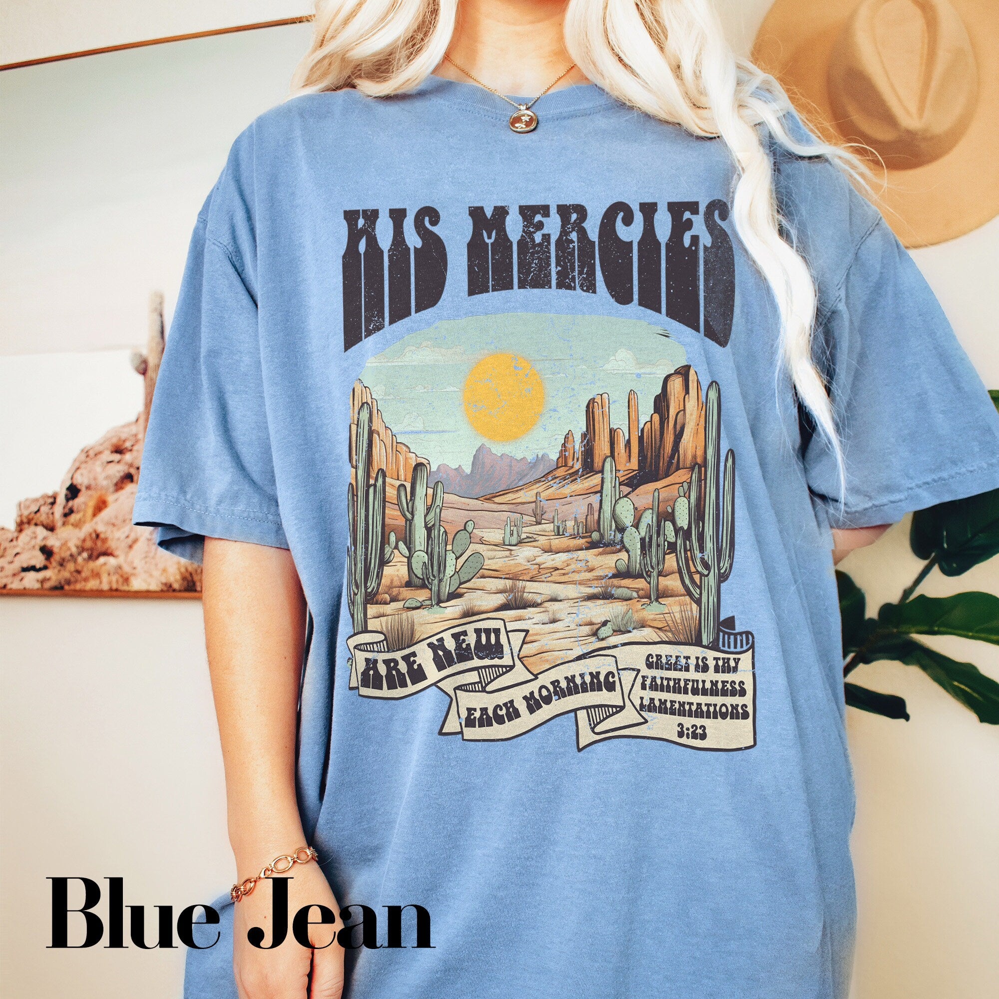 a woman wearing a blue tshirt with a desert scene on it