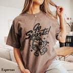 a woman sitting on top of a couch wearing a brown shirt
