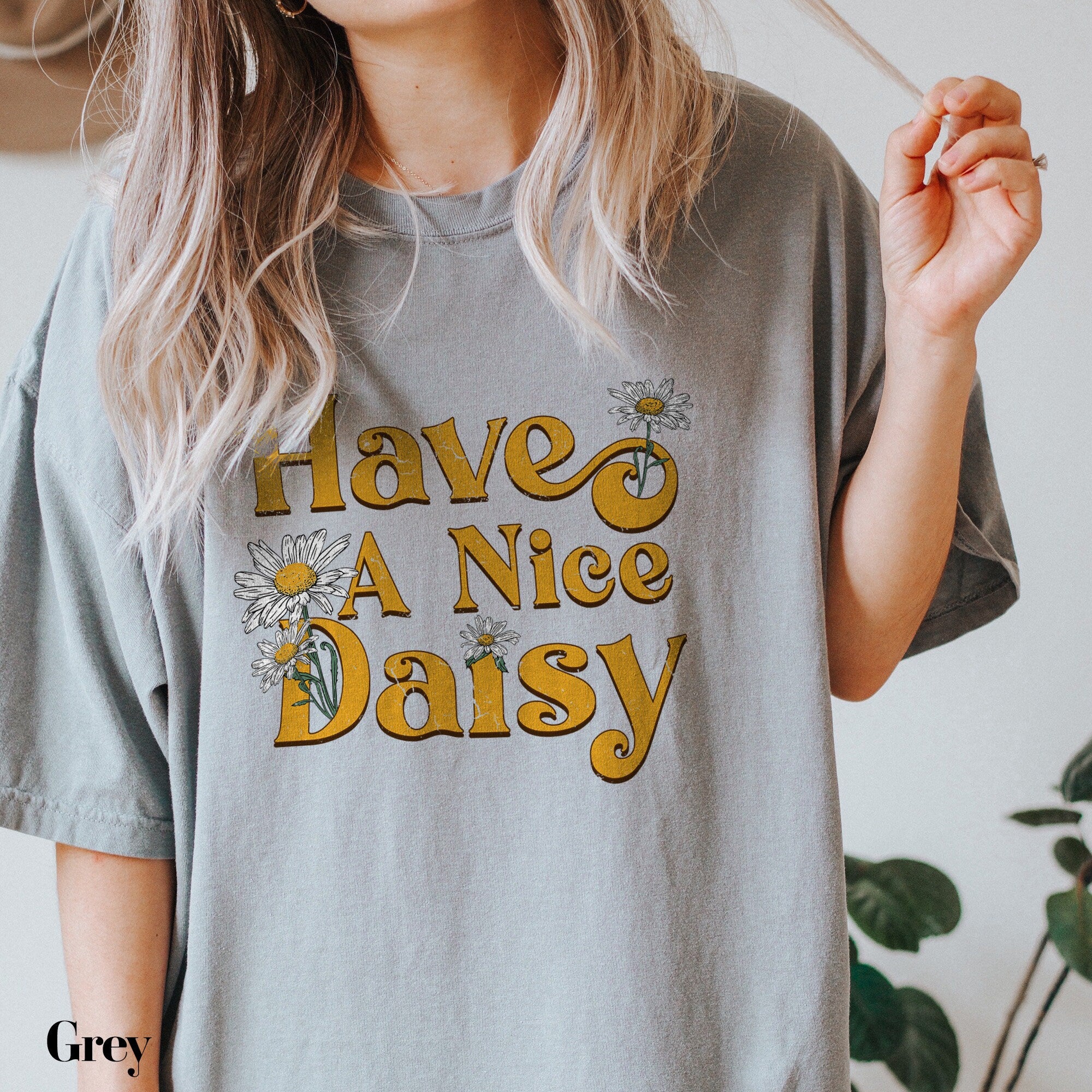a woman holding a cigarette and wearing a t - shirt that says have a nice