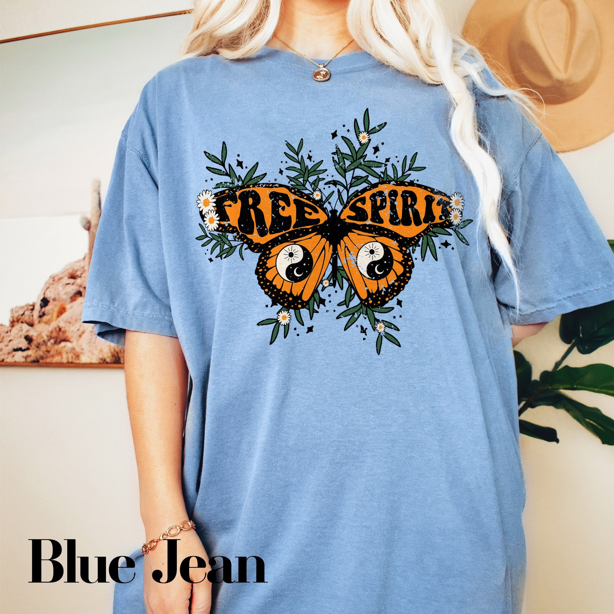 a woman wearing a blue tee shirt with a butterfly on it