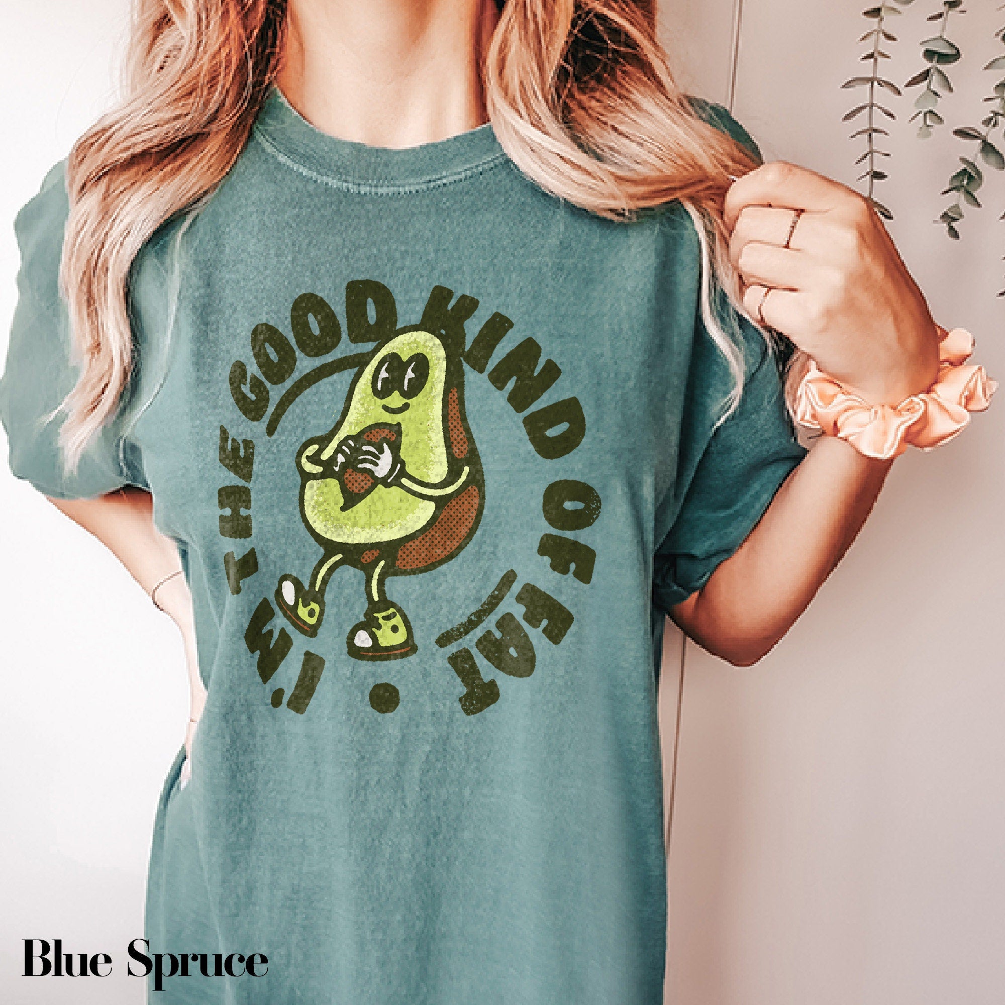 a woman wearing a green t - shirt with an avocado on it
