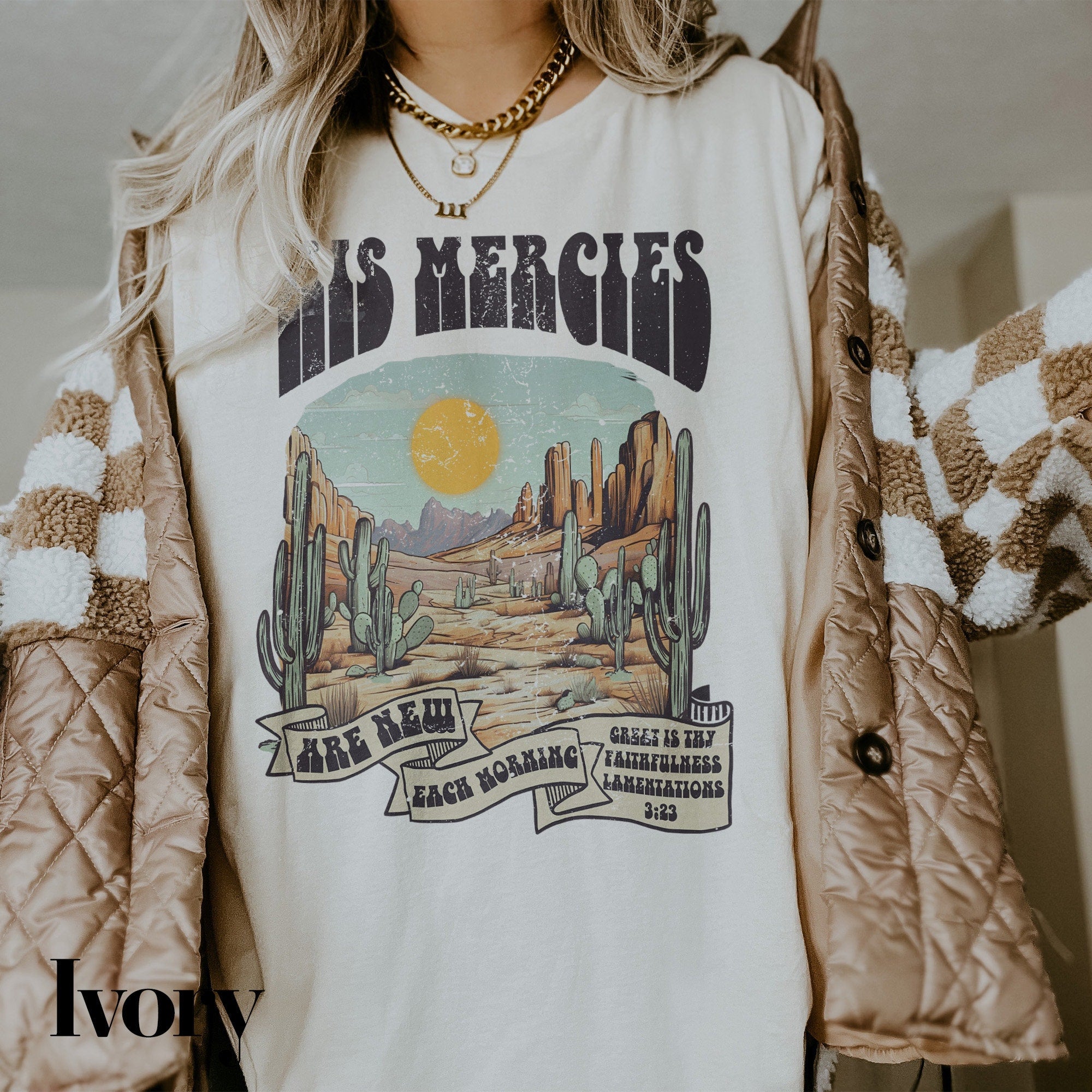a woman wearing a white shirt with a desert scene on it