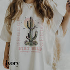 a woman wearing a white shirt with a cactus on it