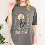 a woman wearing a gray shirt with a cactus on it
