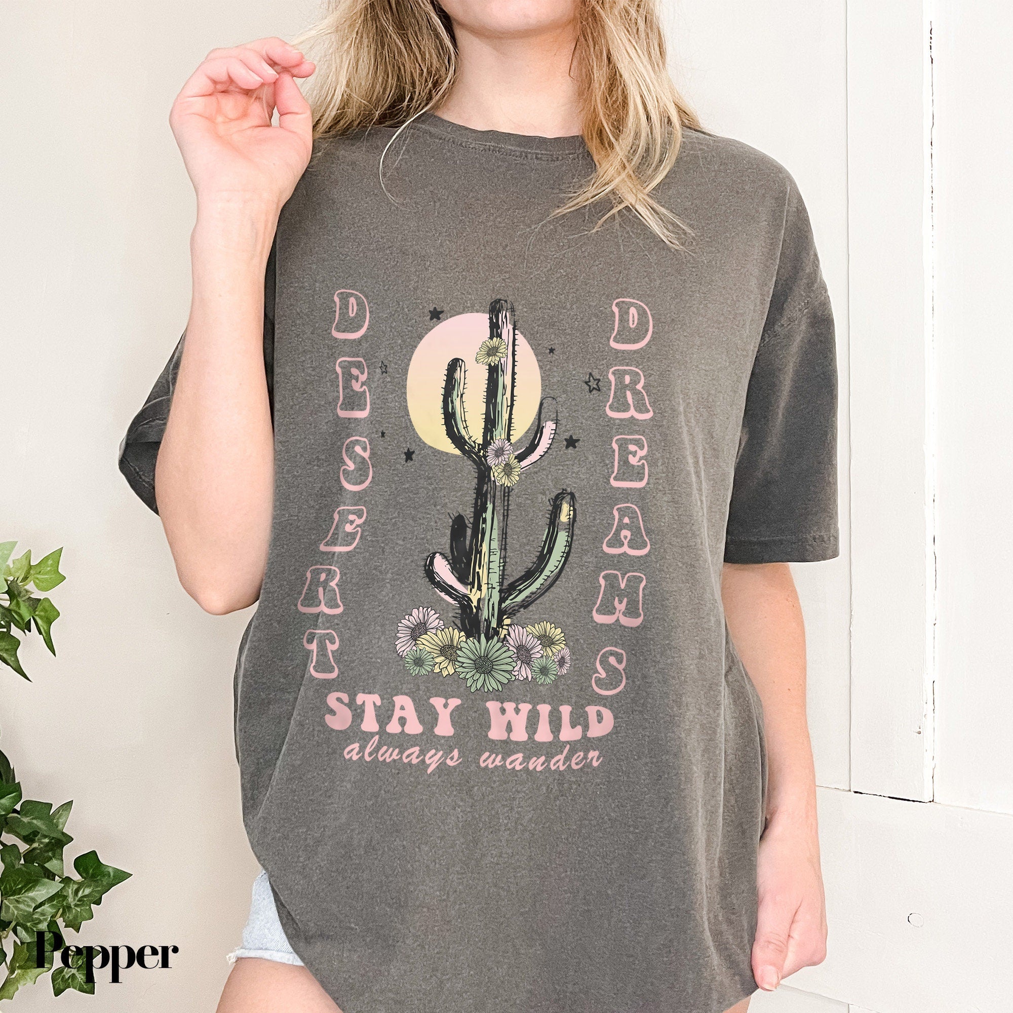 a woman wearing a gray shirt with a cactus on it