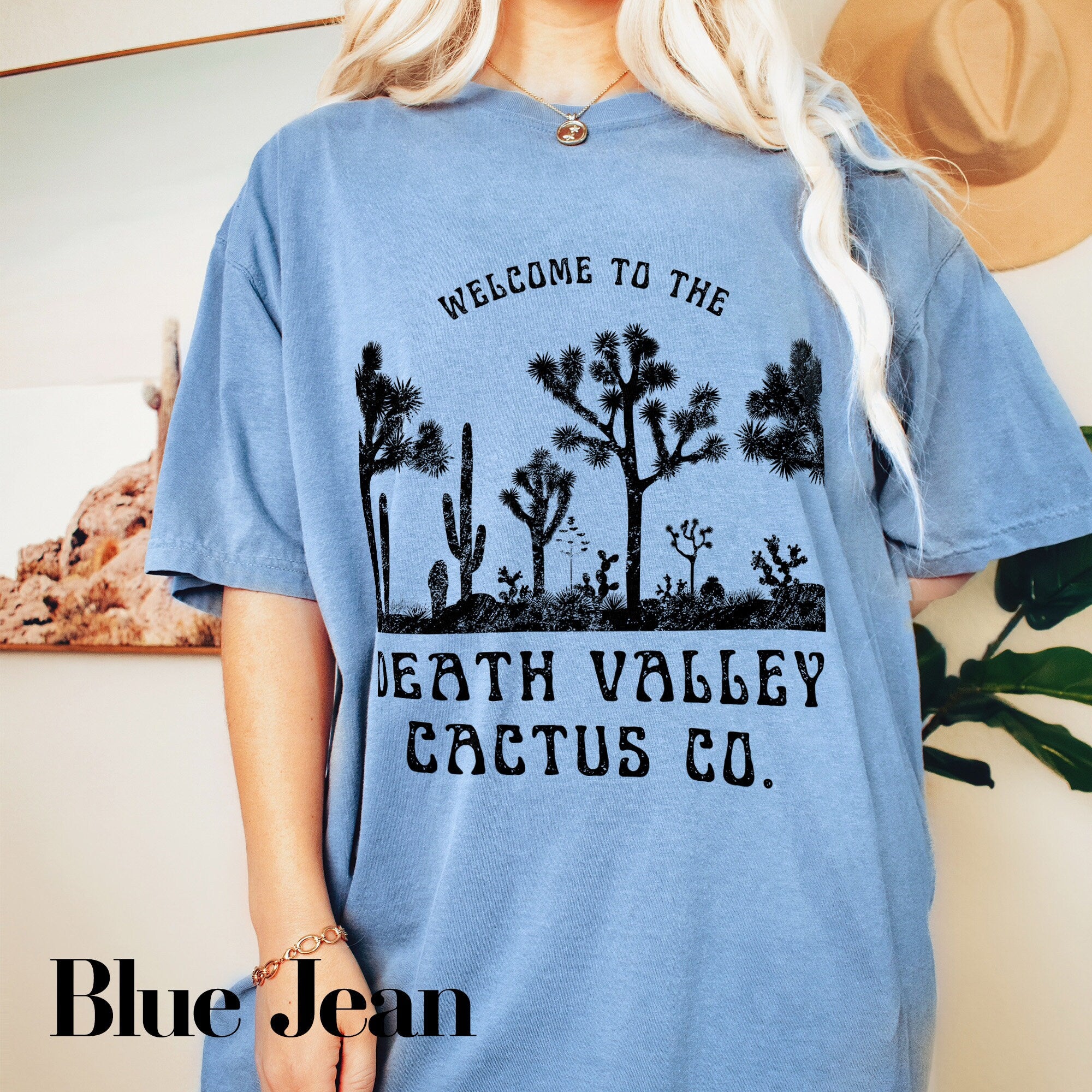a woman wearing a blue t - shirt that says, welcome to the death valley