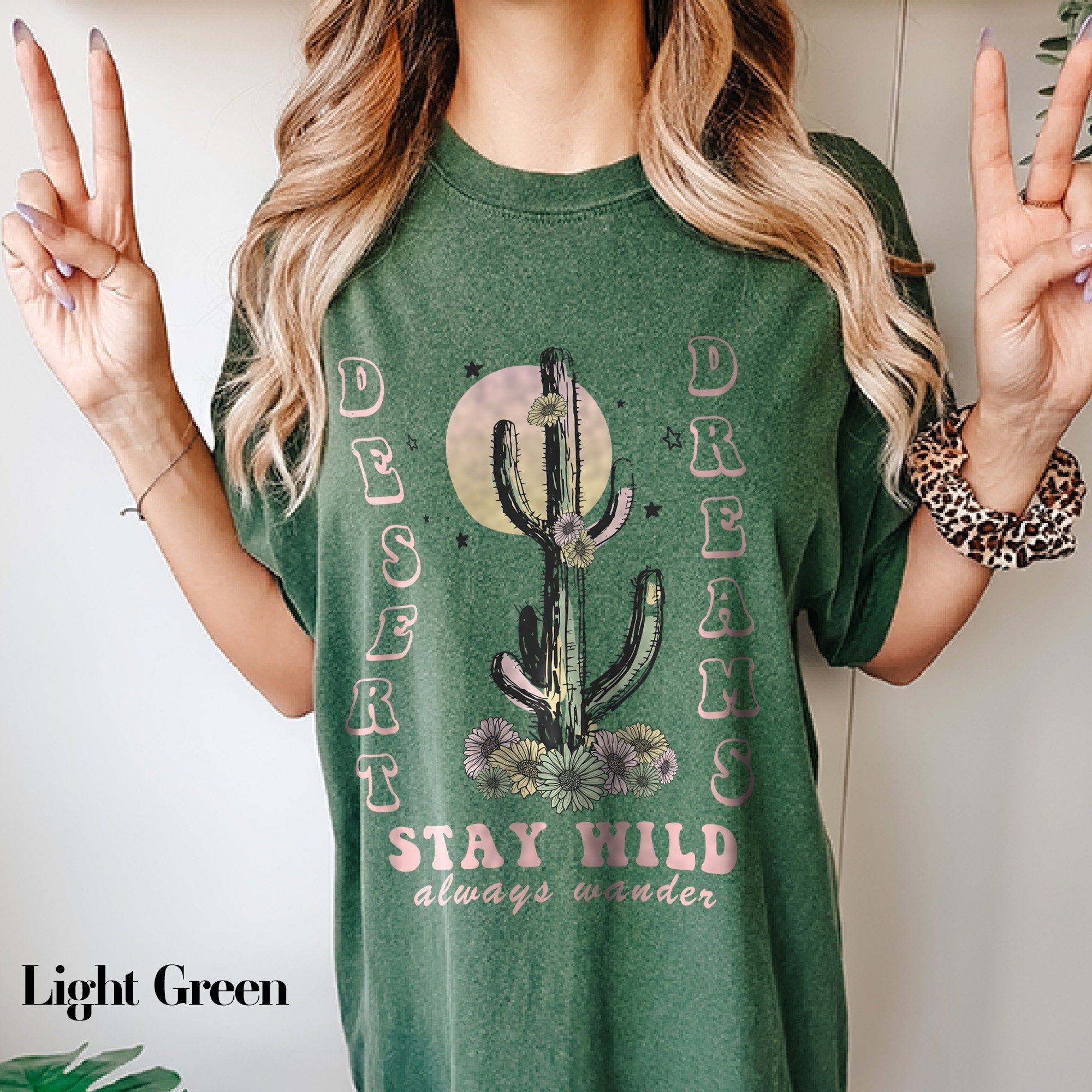 a woman wearing a green shirt with a cactus on it