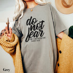 a woman wearing a grey t - shirt that says do not fear for am with