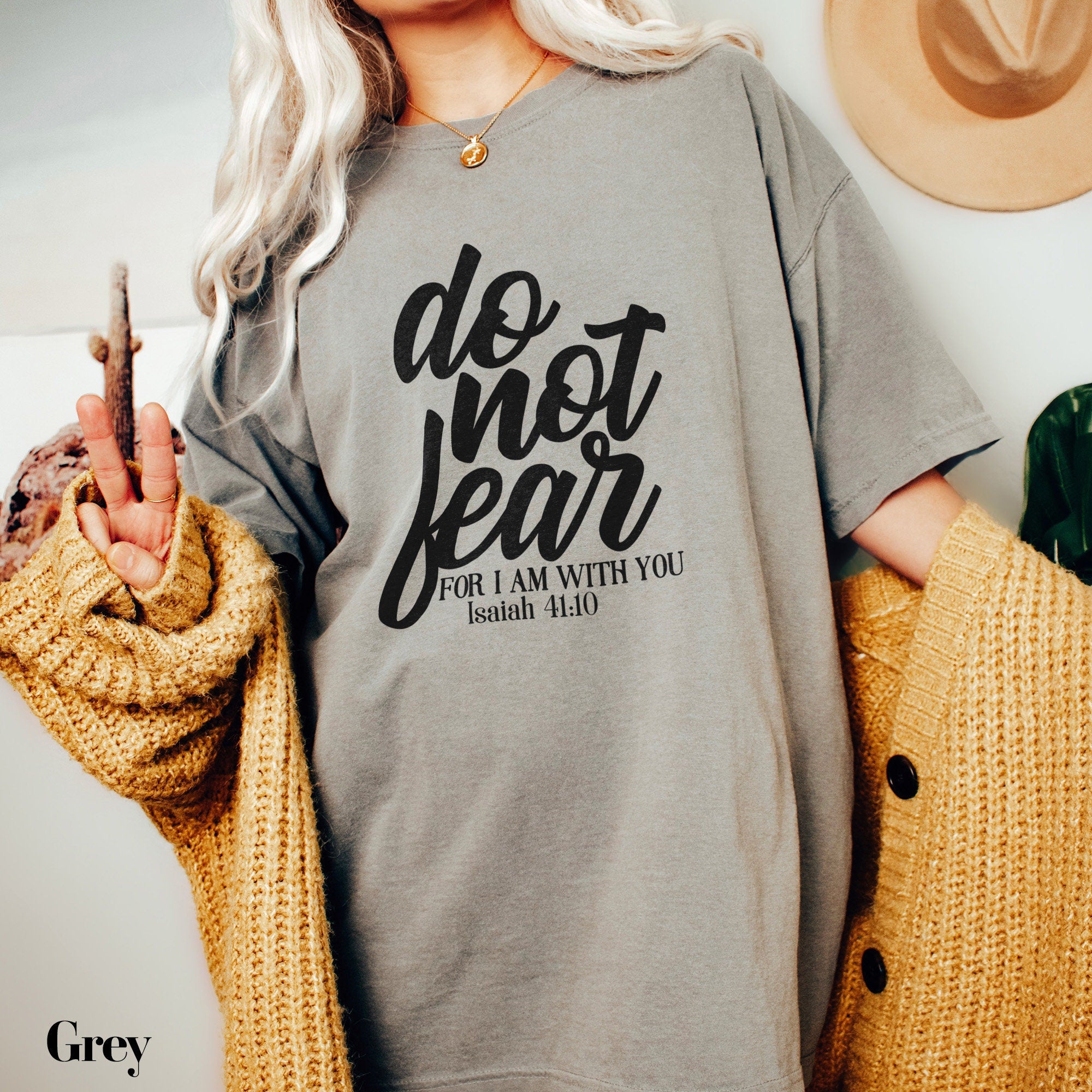 a woman wearing a grey t - shirt that says do not fear for am with