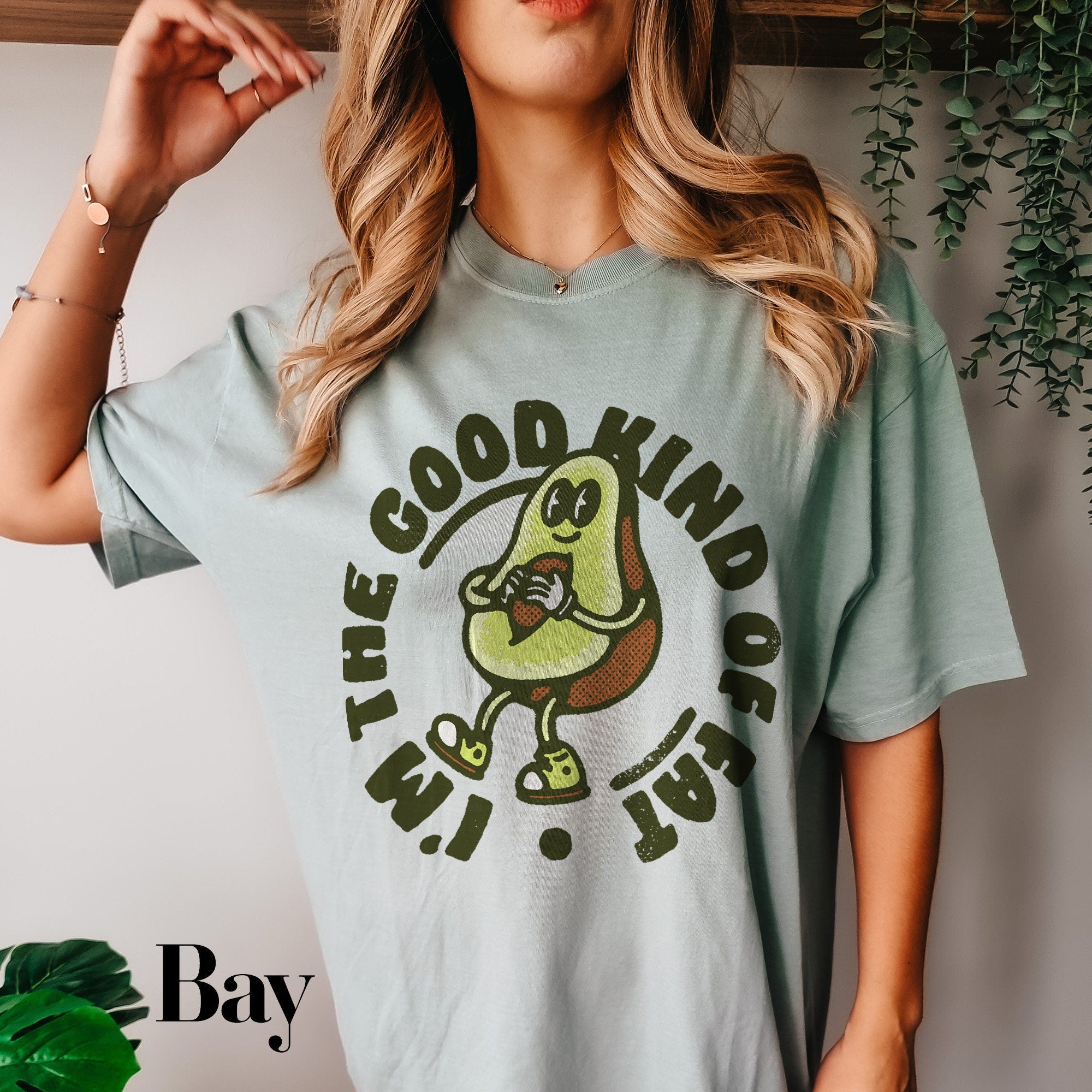a woman wearing a t - shirt that says the good kind of avocado