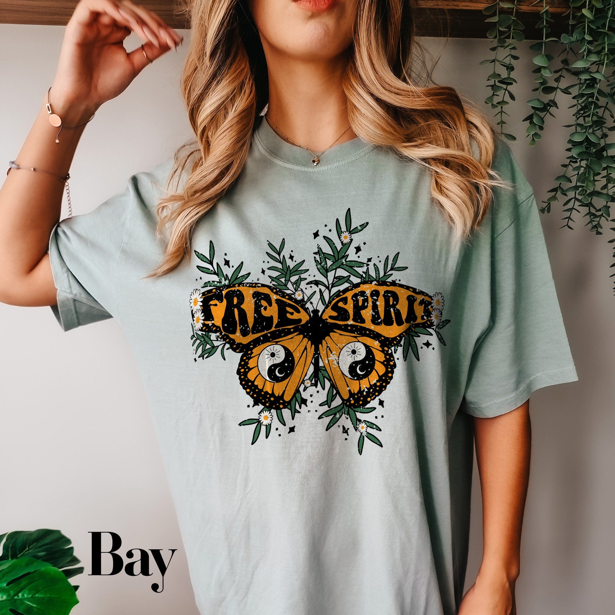 a woman wearing a tee shirt with a butterfly on it