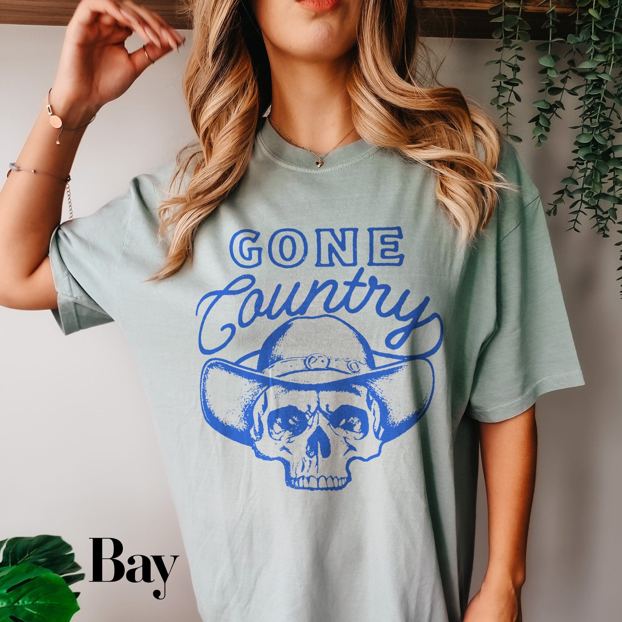 a woman wearing a gray shirt with a skull on it