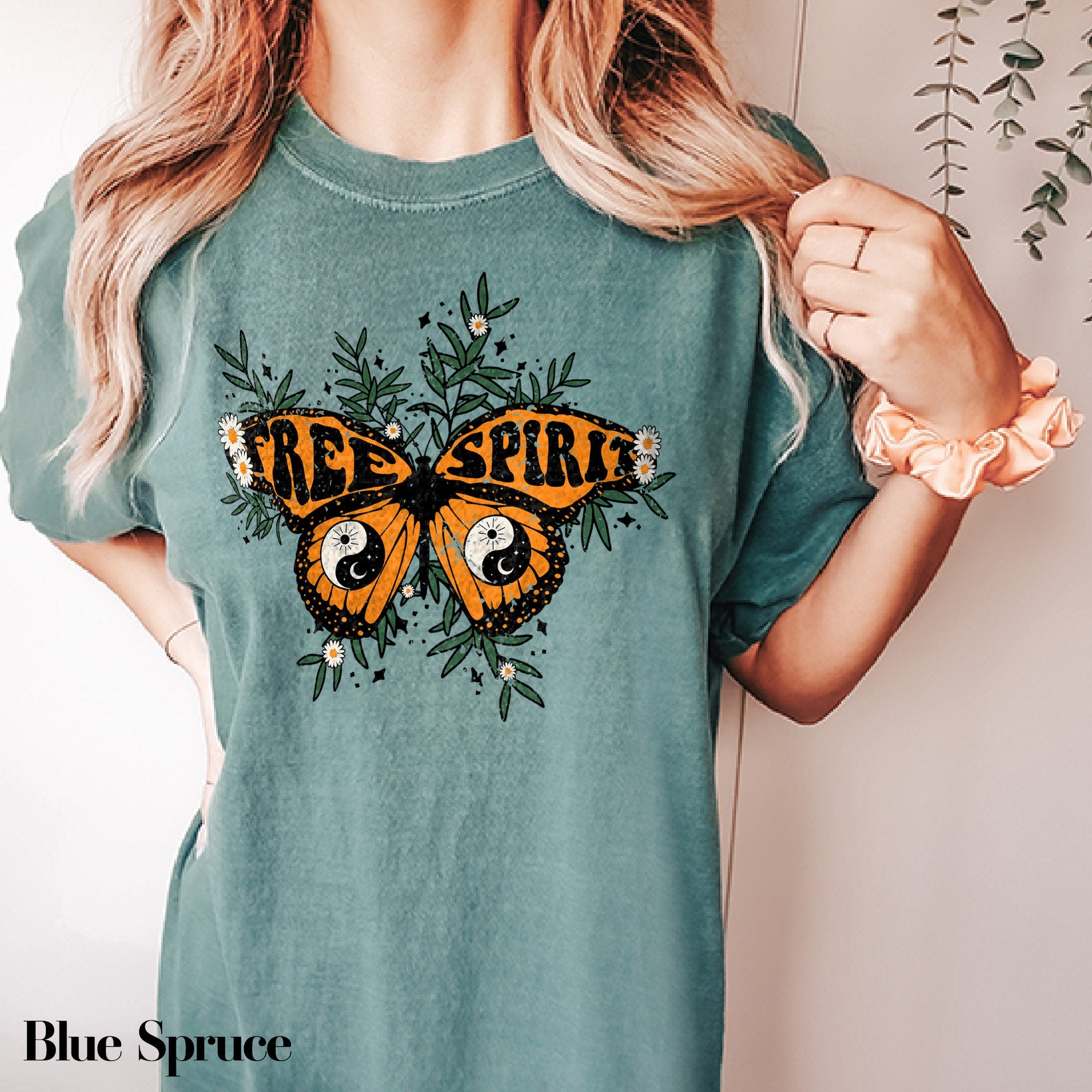 a woman wearing a green shirt with a butterfly on it
