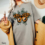 a woman wearing a grey shirt with a butterfly on it