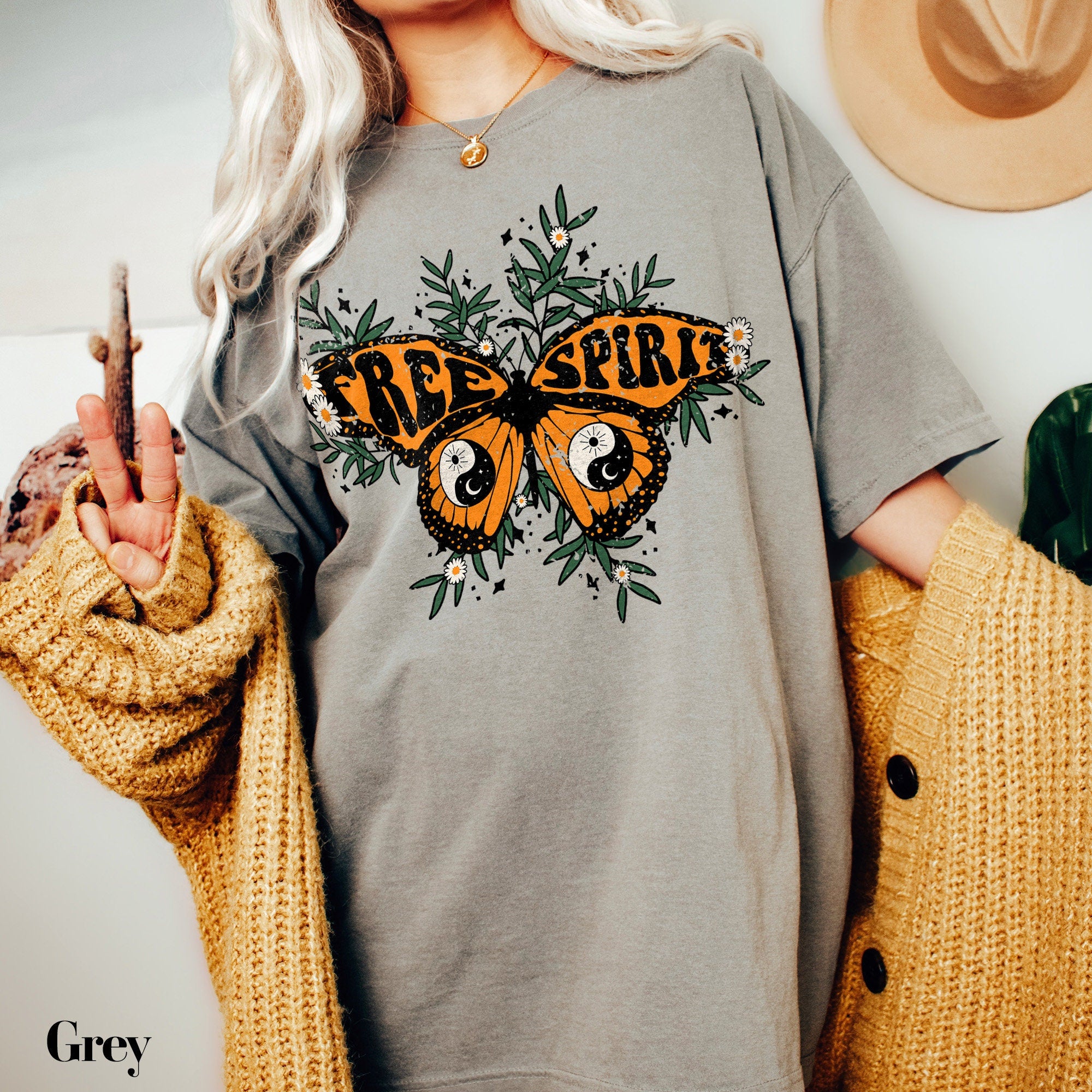 a woman wearing a grey shirt with a butterfly on it