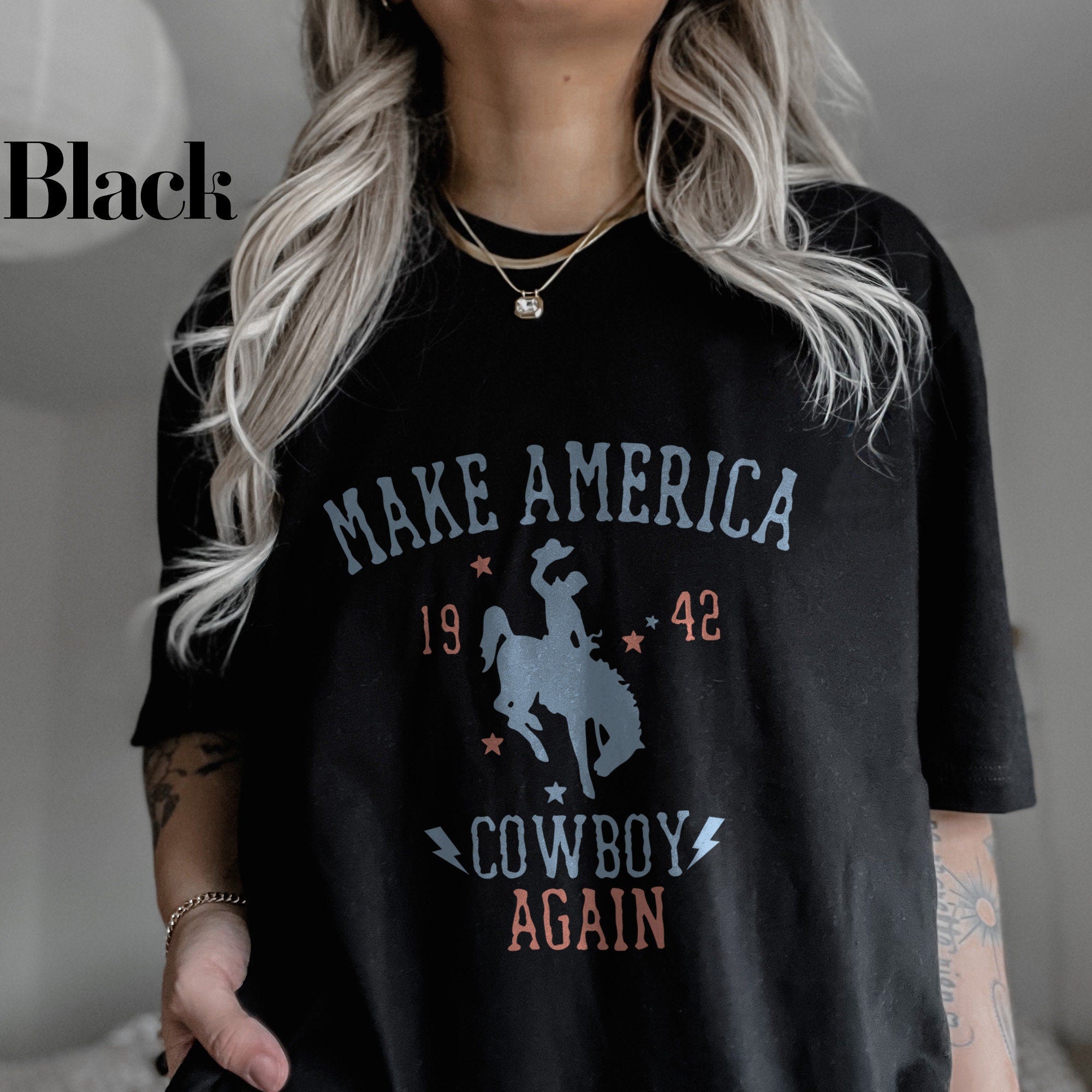 a woman wearing a black t - shirt that says make america cowboy again